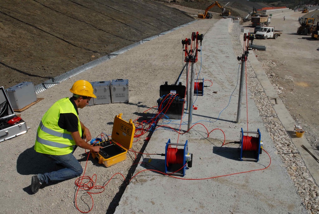Ingeniero realizando ensayo geotécnico in-situ con equipo eléctrico en talud